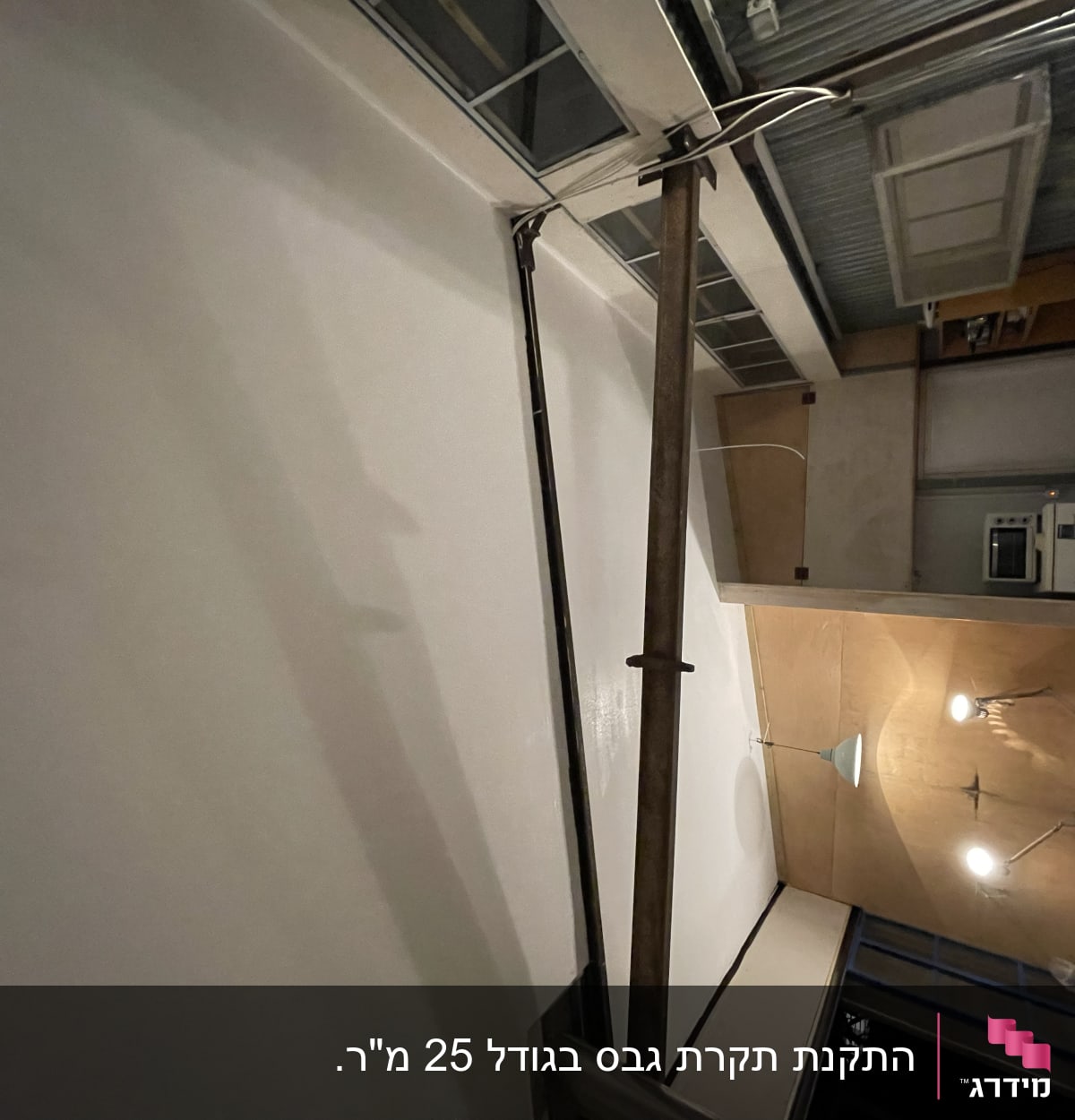 קיר גבס עם צינור מתכת ותאורה